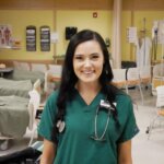Photo of a female undergraduate nursing student in the Elms skills lab