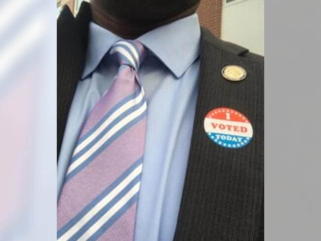 Photo of a 'vote' pin on Dr. Dumay's blazer