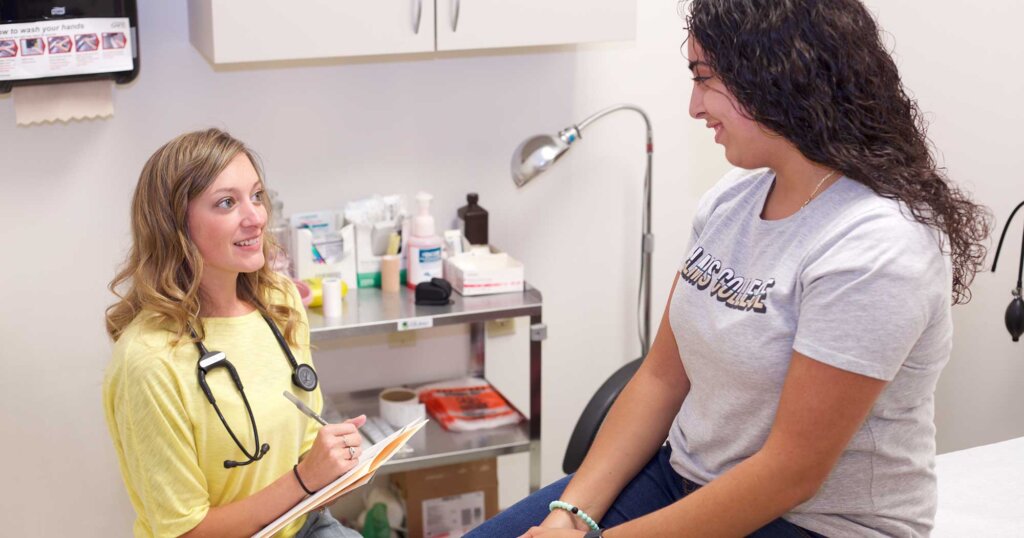 Photo of Health Center Director Jessie Chenier, RN, helping a student