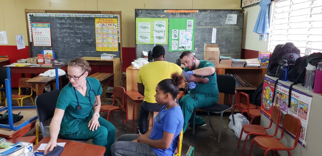 Photo of students in the accelerated second degree in nursing program, helping patients in Jamaica