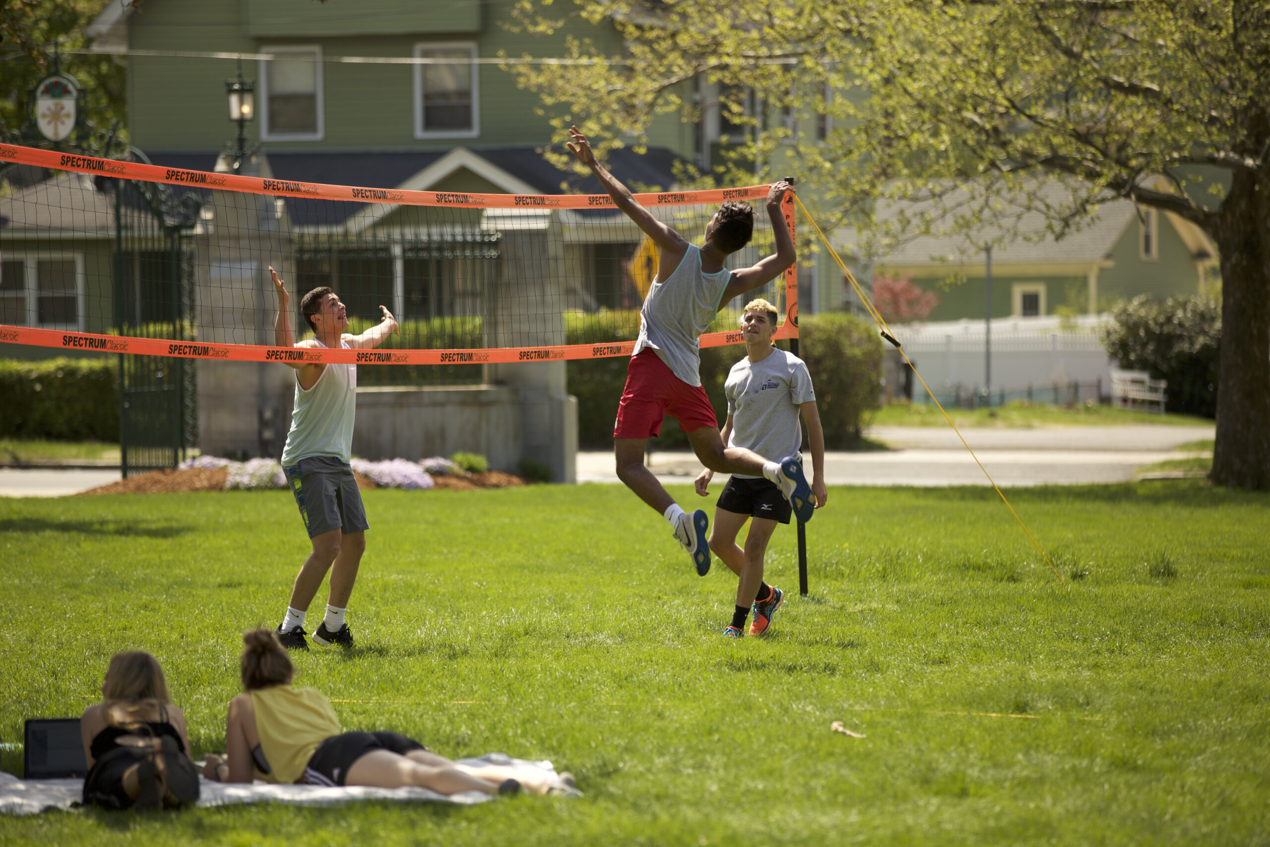 Photo of students playing volleyball on the lawn in front of Berchmans Hall