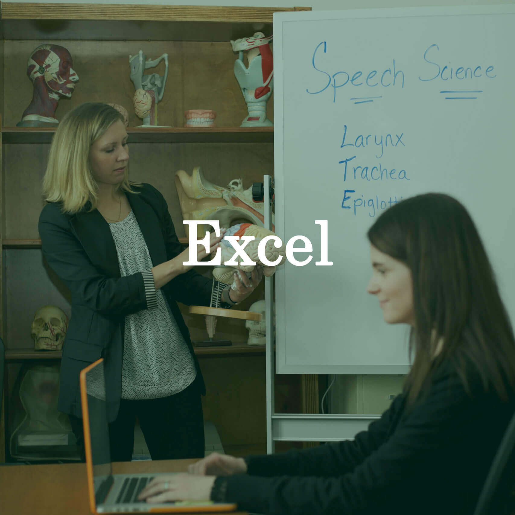 Photo of the professor and a student with a laptop with a text overlay that reads "Excel."