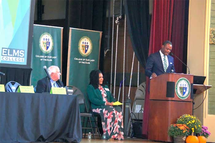 Dr. Dumay speaking at the podium in Berchmans Hall at Elms College at a Western Massachusetts Literacy Collaborative event, Cynthia Lyons, CEUE, Springfield public schools