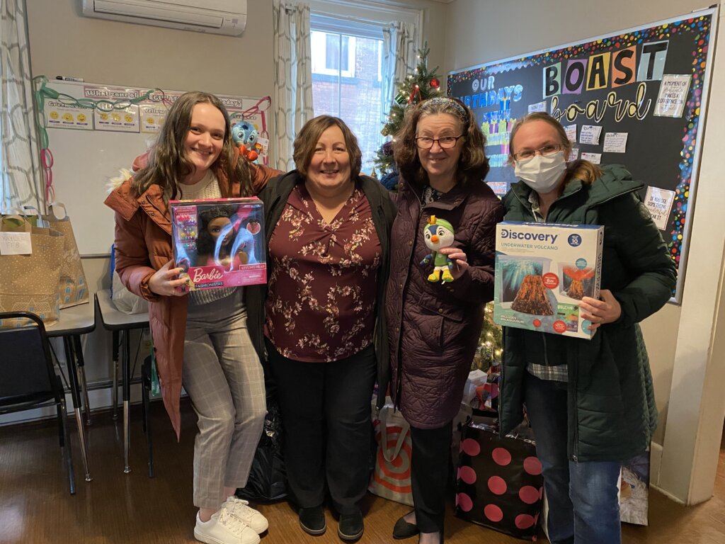 Four women holding presents