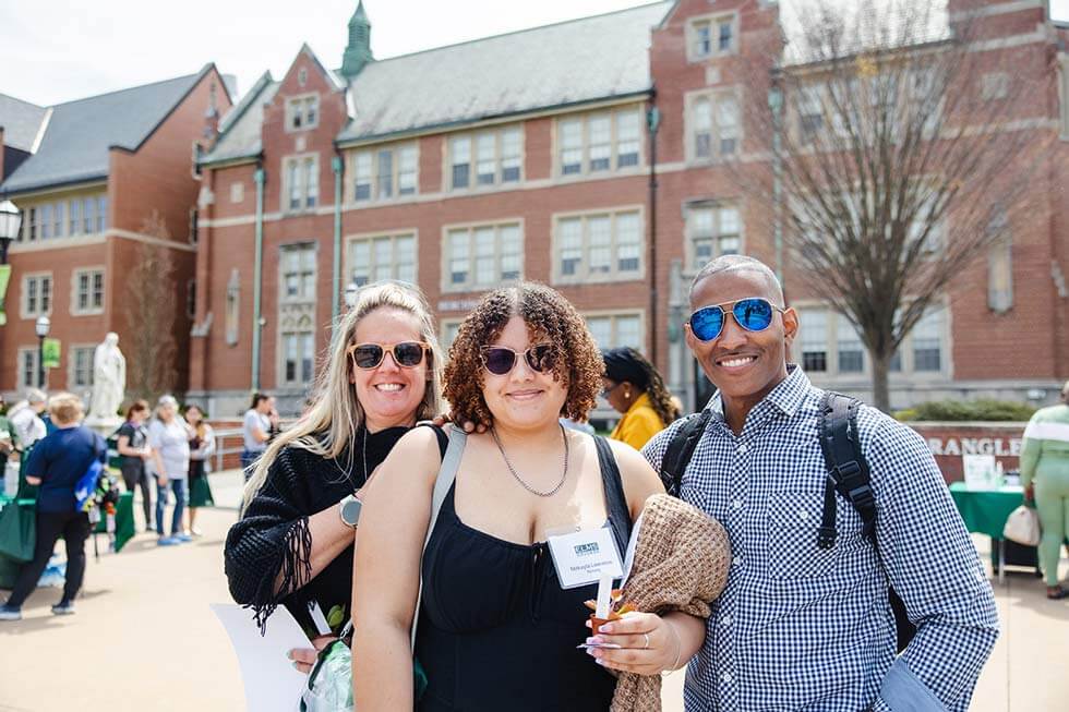Photo of a freshman visiting the Elms Quad with their parents