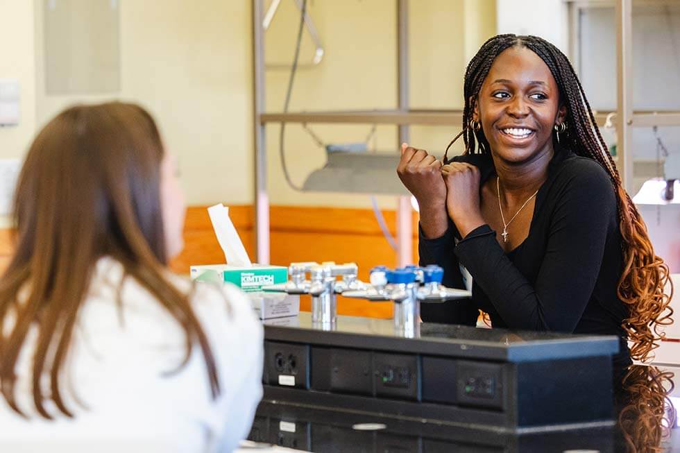 Photo of two female students in a lab setting