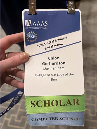 photo of Chole Gerhardson holding an award for placing in the S-STEM Scholars and PI Meeting computer science Conference 2024