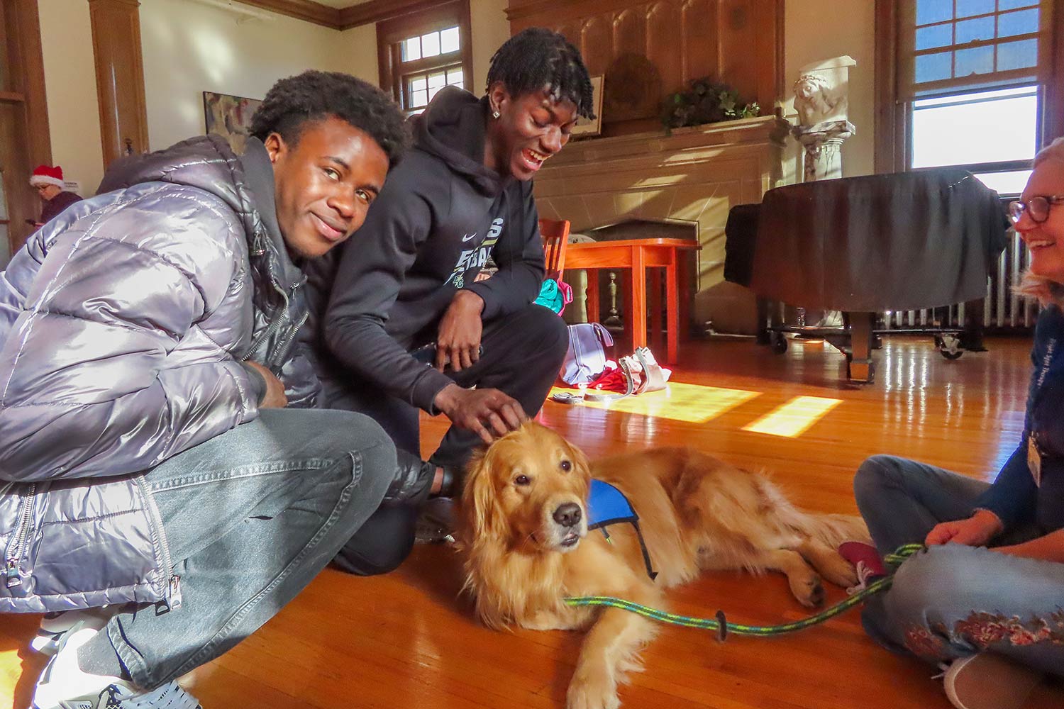 Photo of two male students and a dog