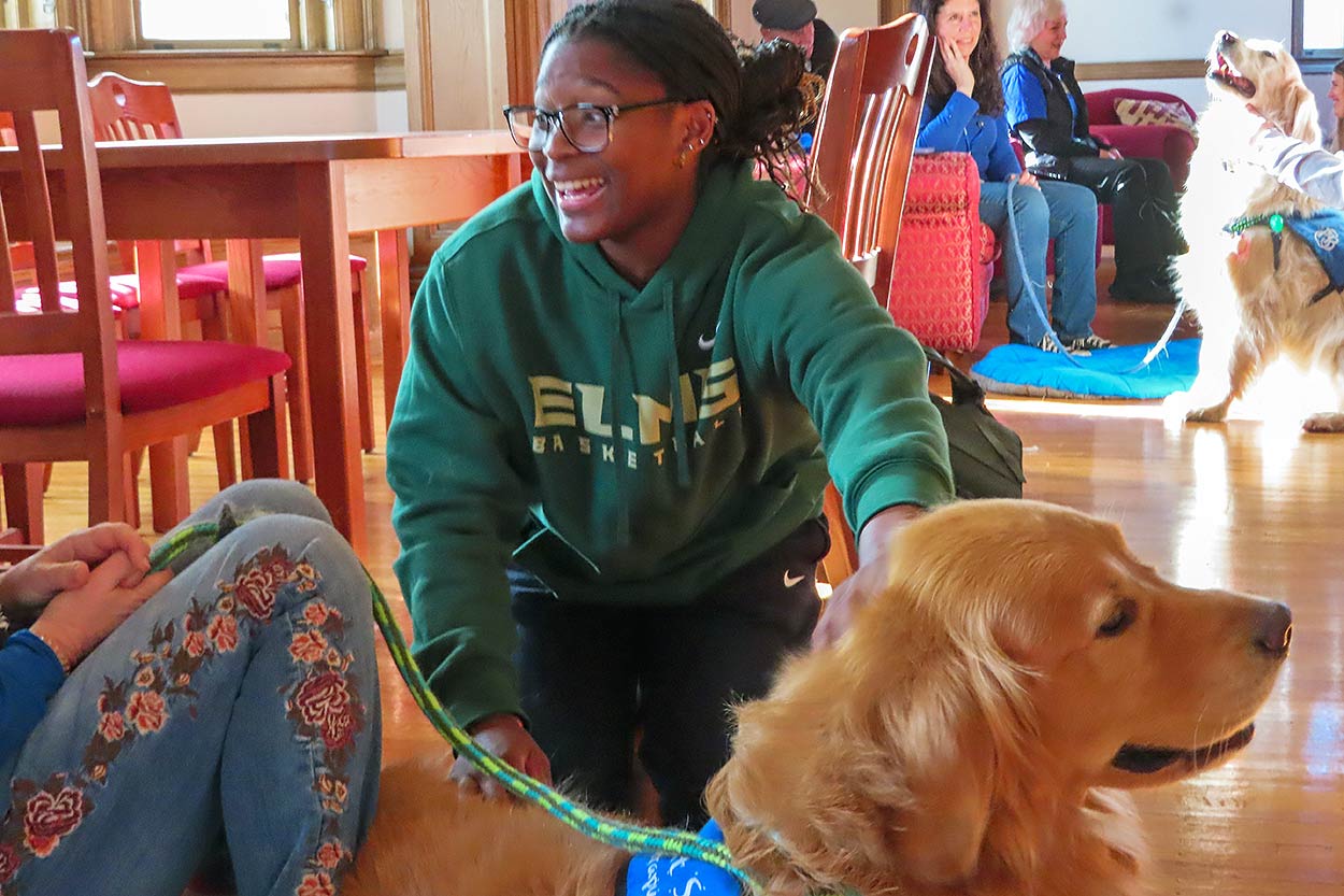 Photo of a female student and a happy dog