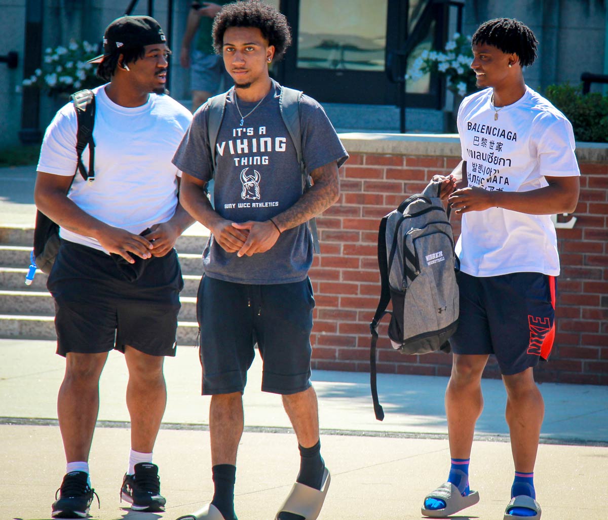 Photo of three male students on the quad