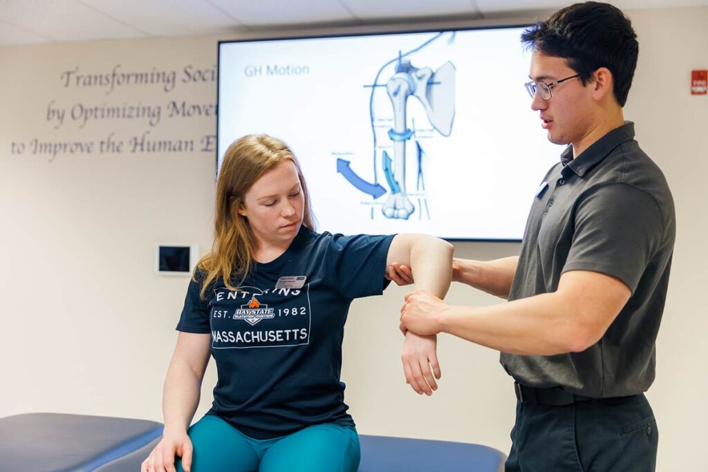 Photo of a man holding a woman's arm and reviewing how muscles work