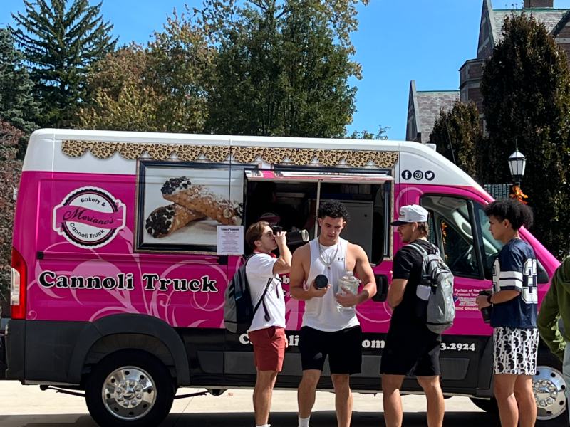 Photo of four students outside a food truck