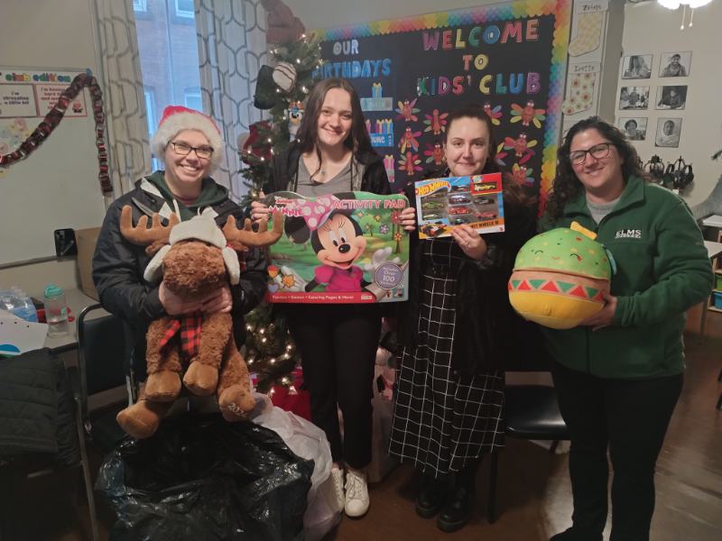 Photo of four people holding presents