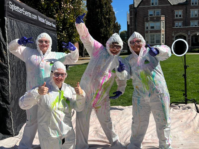 Four students posing in coveralls