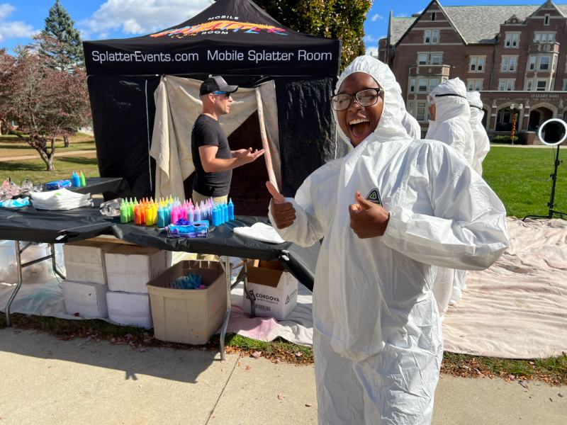Photo of a student in coveralls at a paint event