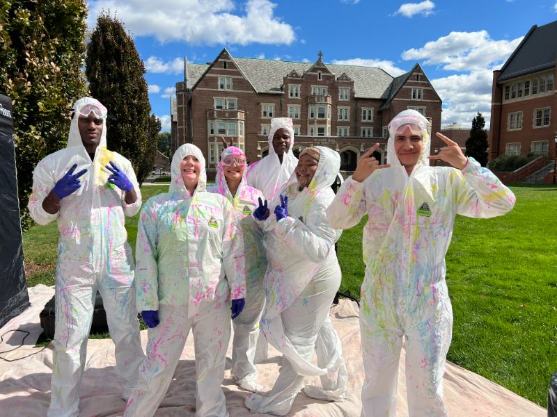 Photo of students wearing paint stained coveralls