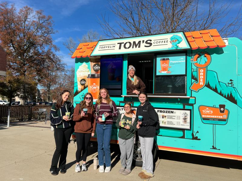 Photo of five students in front of a food truck