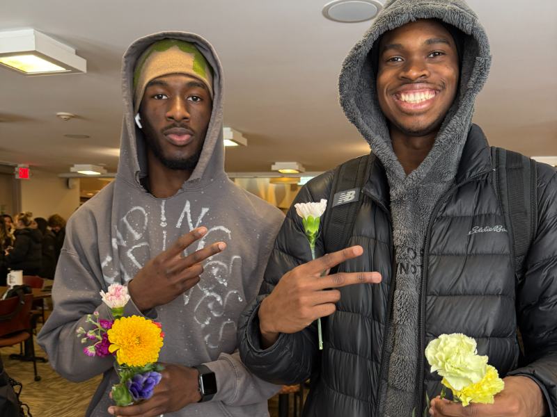 Photo of two students holding flowers