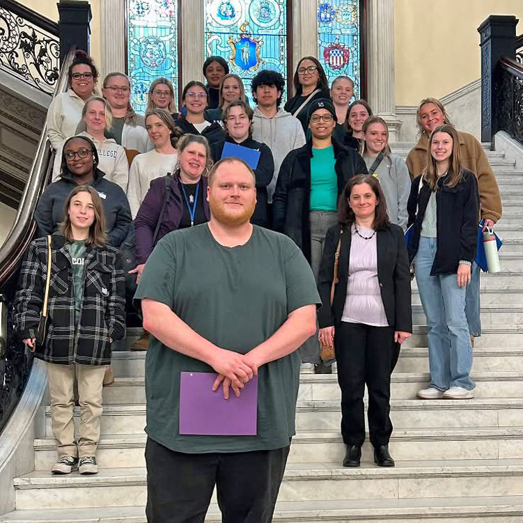 Photo of many students and staff standing inside a building