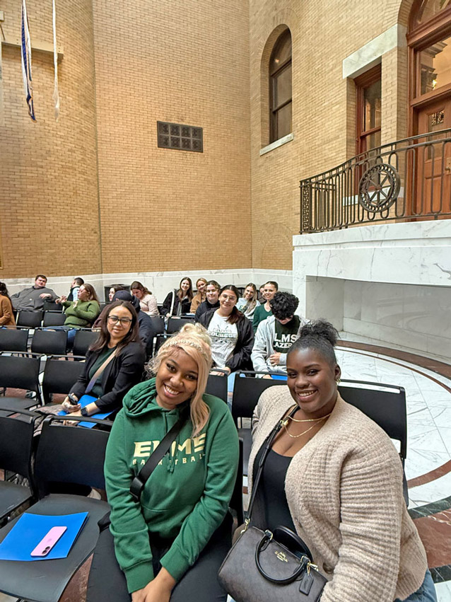 Photo of many students and staff sitting inside a building