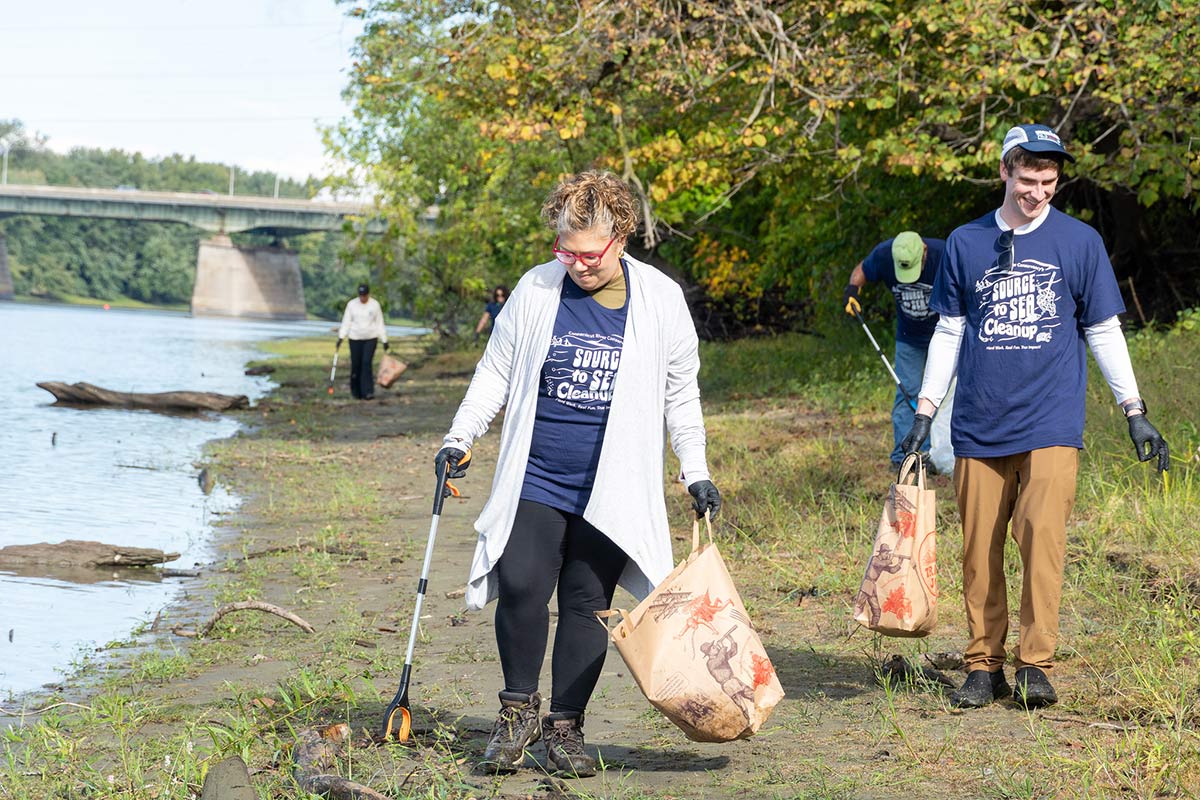 Several Elms College students cleaning up river