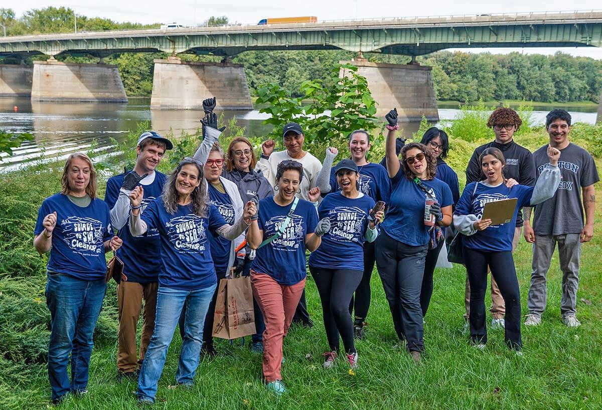 Group photo of Elms students and faculty cleaning up river