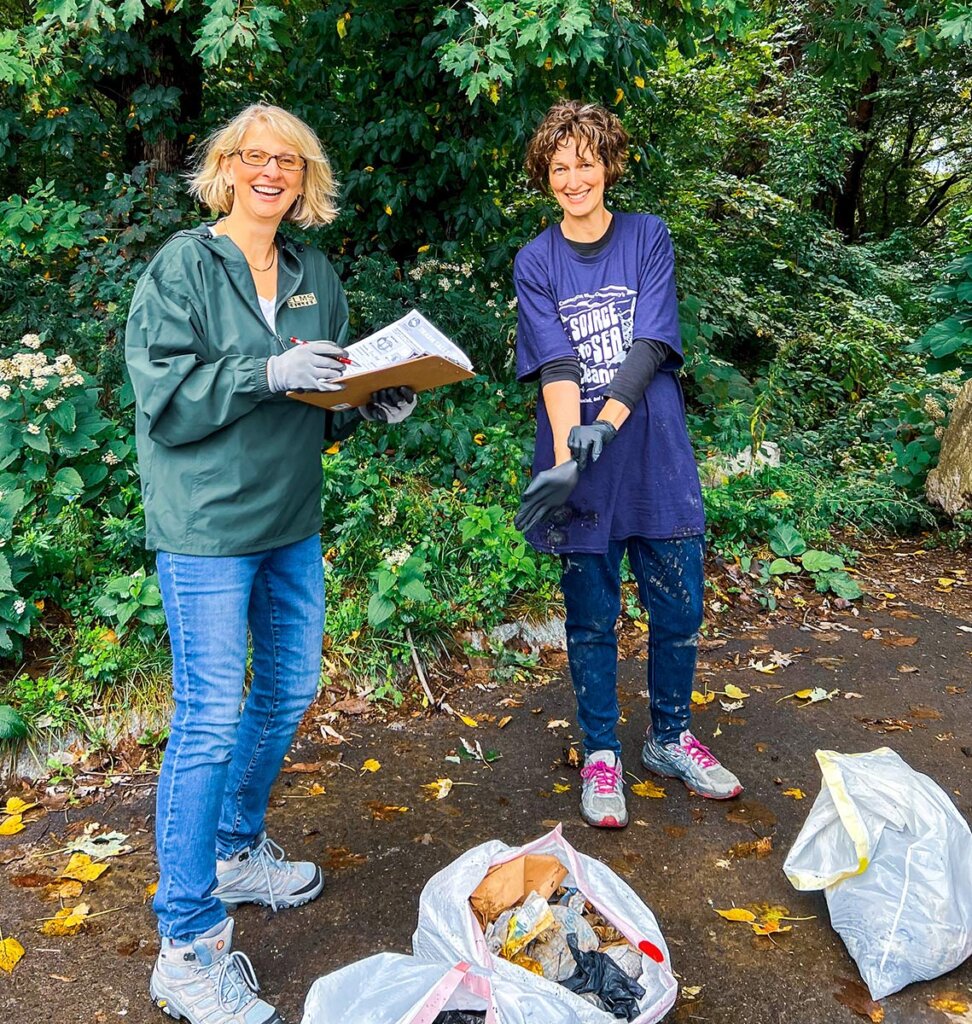 2 Elms College faculty cleaning up the riverbank