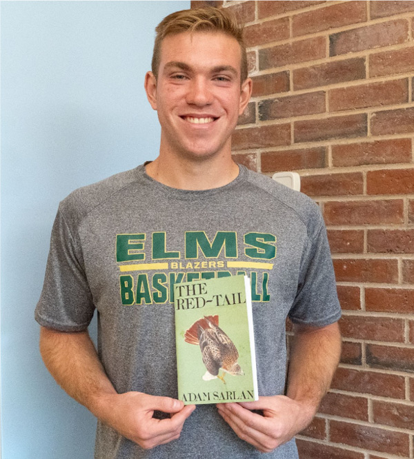 Portrait of Adam Sarlan holding his book.