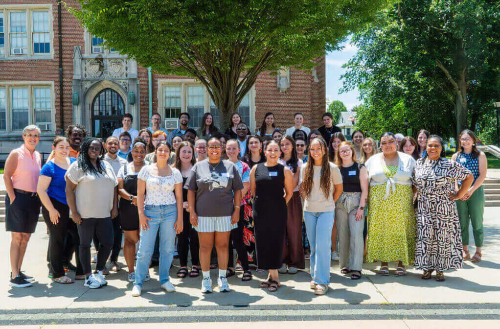 Group photo of many people standing in the quad at Elms College