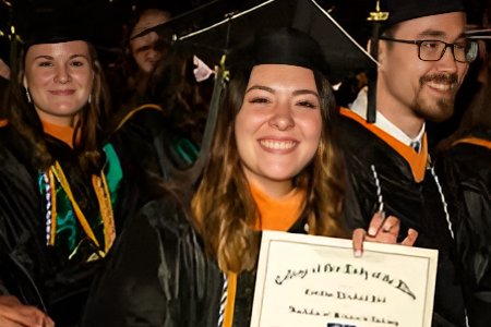 Photo of a women in graduation clothing holding a certificate